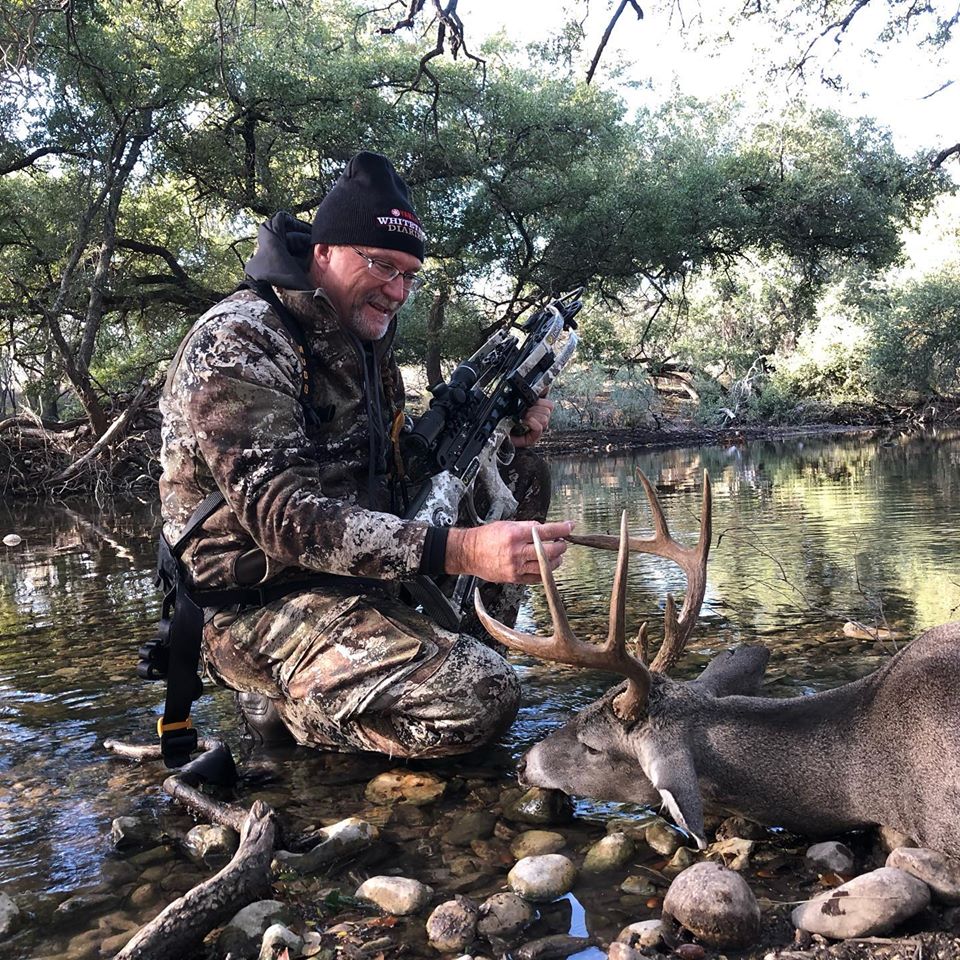 Hunter smiling with deer and crossbow