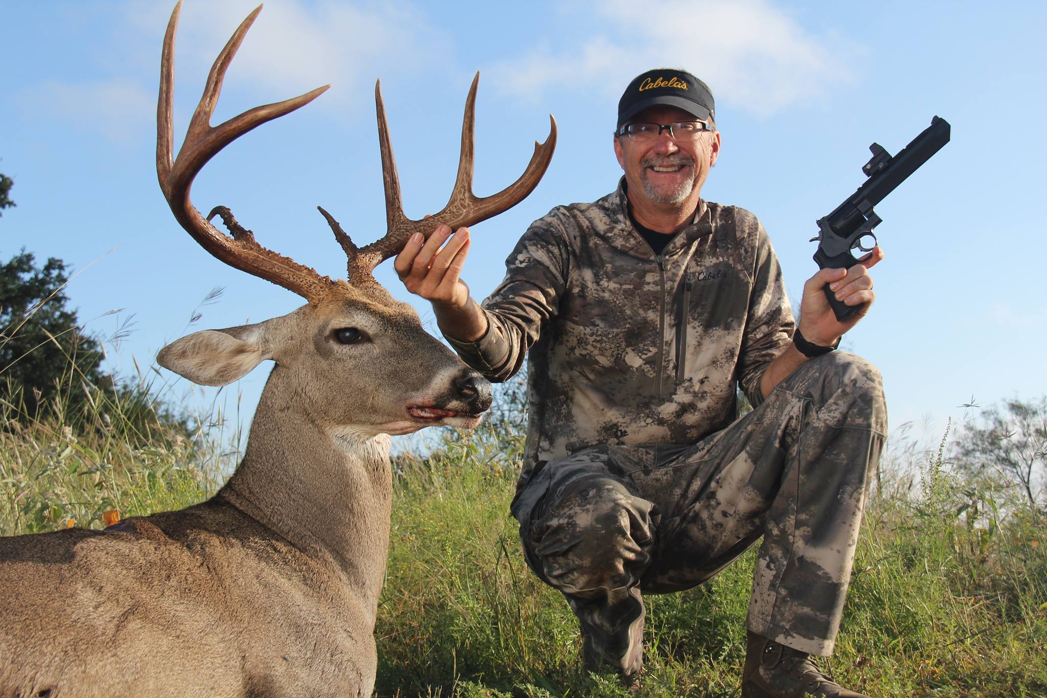 Hunting posing with deer and handgun