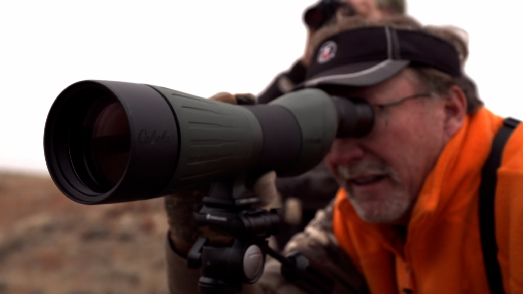 Hunter looking through a spotting scope