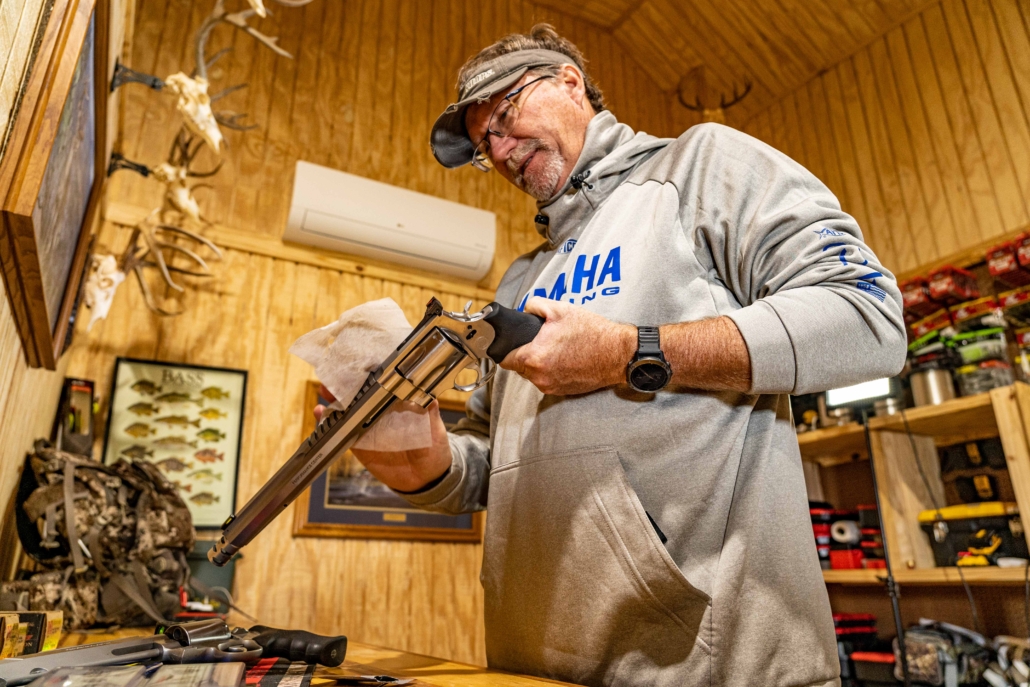 man cleaning handgun